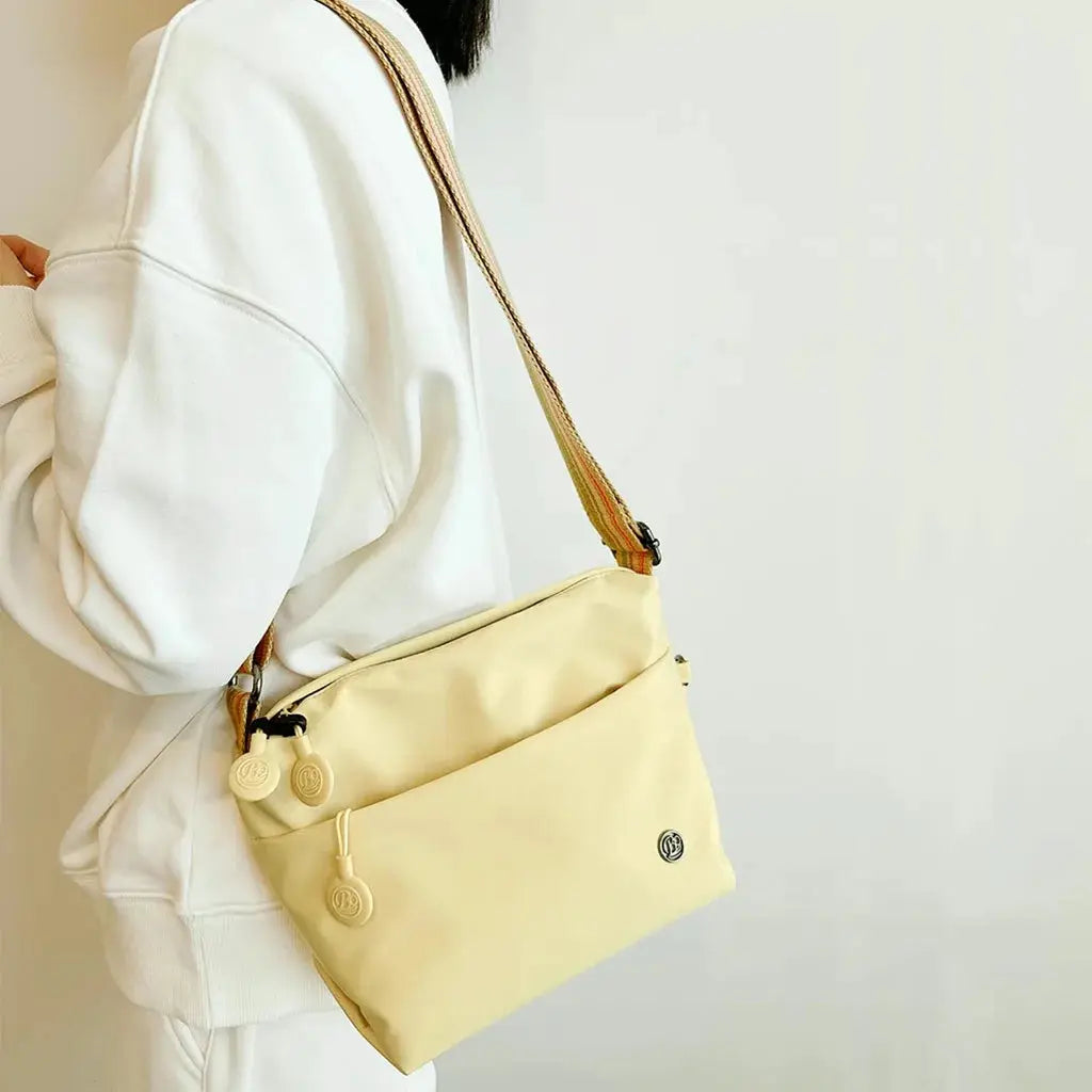 Ultra-light nylon crossbody bag by Simples Market, pale yellow with adjustable wide strap and zipper closure