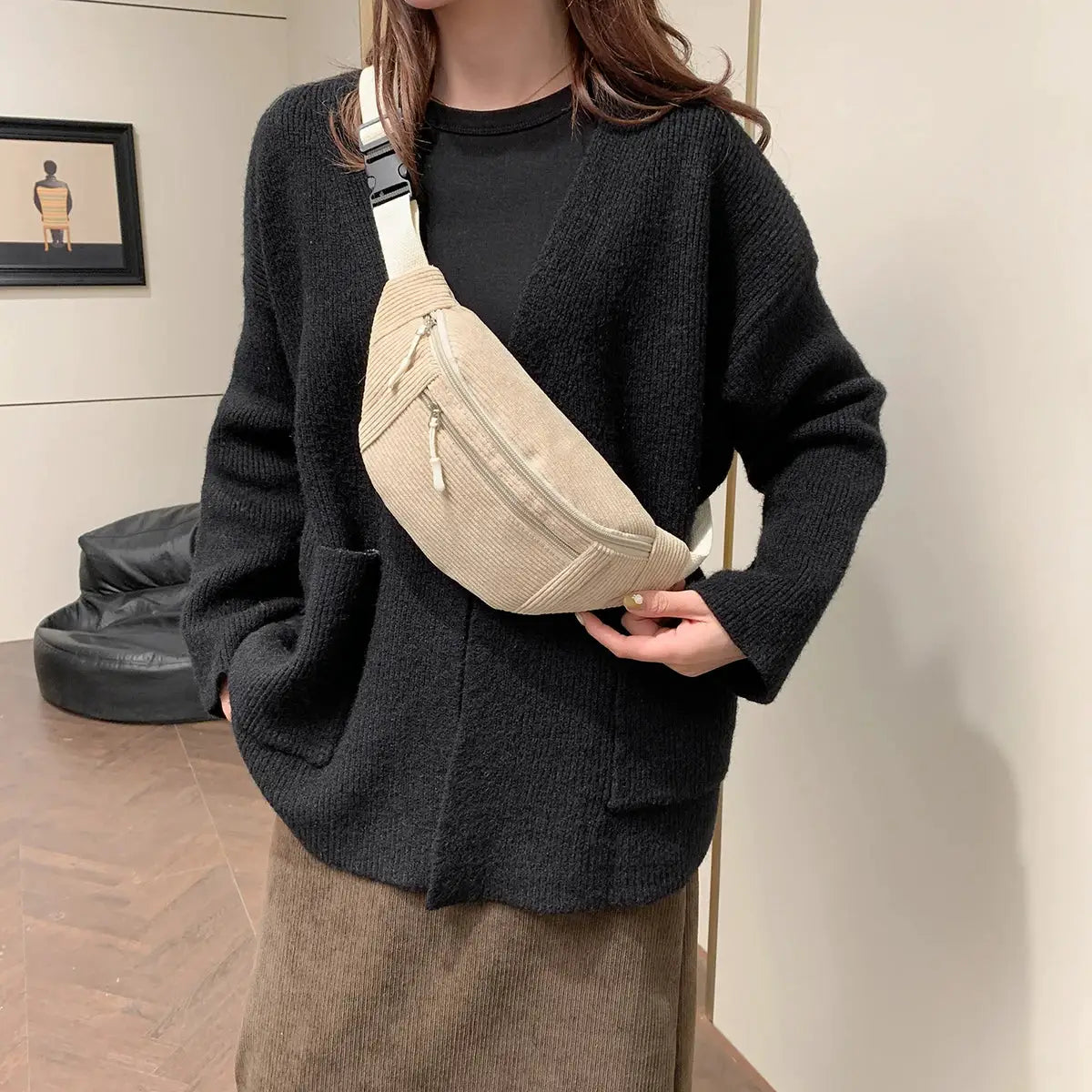 Beige corduroy waist bag with dual zip pockets and white adjustable strap, worn crossbody