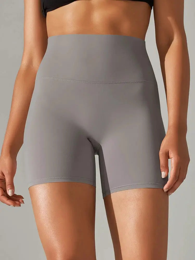 Grey high-waist athletic shorts for women with a tight fit and mid-thigh length.