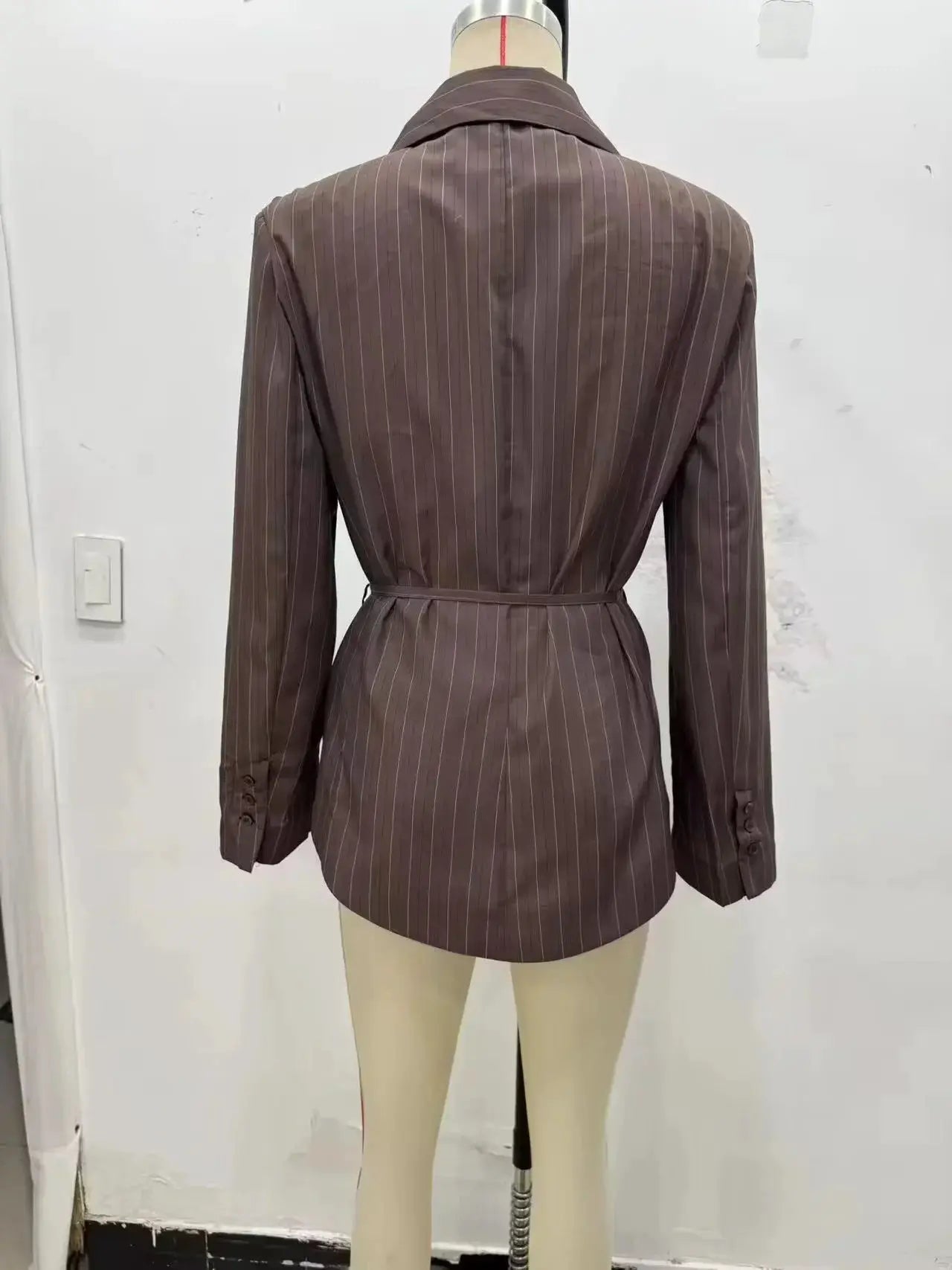 KONDALA brown striped single-breasted blazer with waist sash on mannequin.