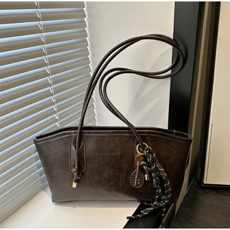 European American retro brown tote bag with long shoulder straps and decorative pendant charms