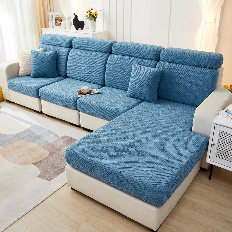 Sofa slipcover set in blue jacquard stretch fabric for sectional with chaise, includes seat cushions and pillows.