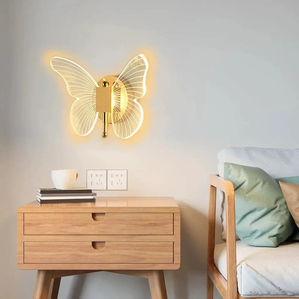 Butterfly LED wall lamp by Simples Market, gold metal with acrylic wings, warm backlit bedside sconce