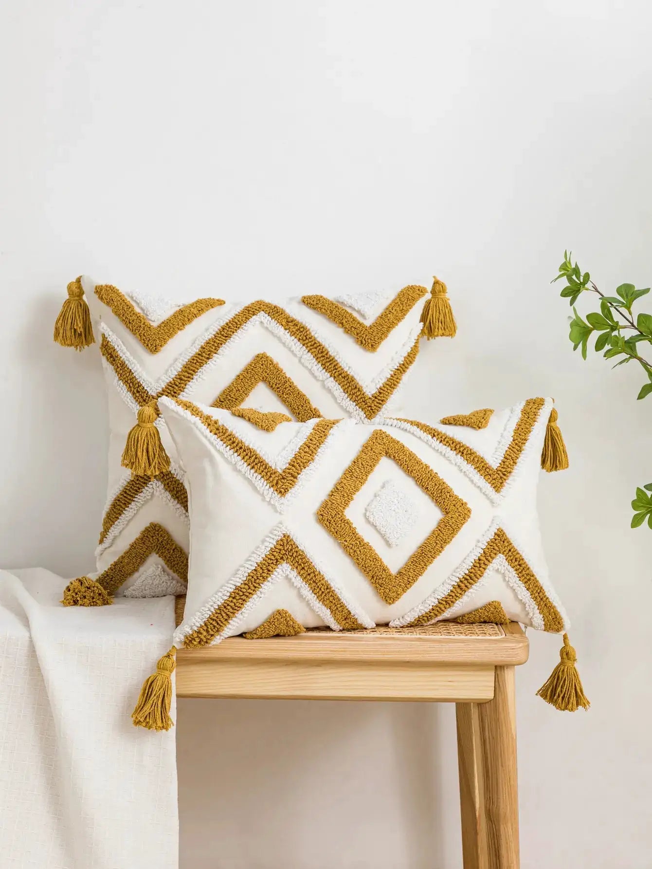 2 white cotton pillow covers with yellow geometric diamond line pattern and tassel trim, boho style