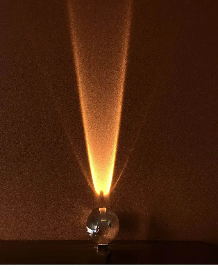 Italian designer egg-shaped table lamp with a crystal ball base projecting warm amber light onto the wall