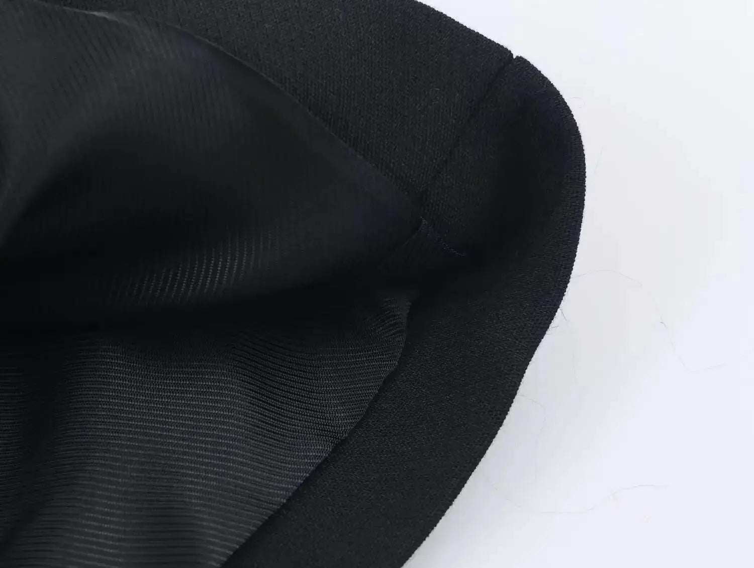 Two-piece women's black suit set; close-up of blazer lining and seam edge