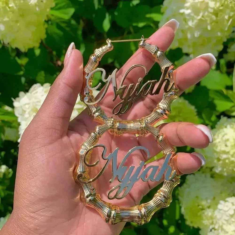 Pair of bamboo hoop earrings with Nyah name script in gold and silver finishes