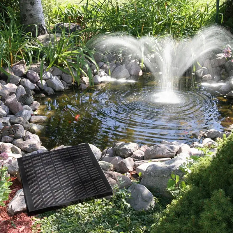 Solar fountain pump panel kit with 6-nozzle jets for ponds; black solar panel beside a garden pond.