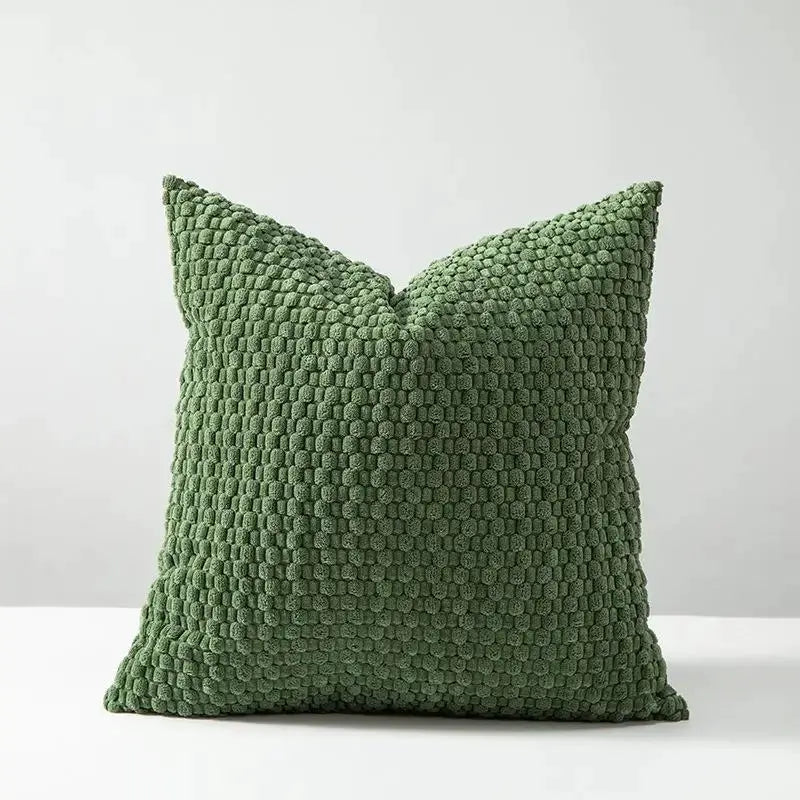 Green velvet cushion cover with a dense looped texture for cozy decor.