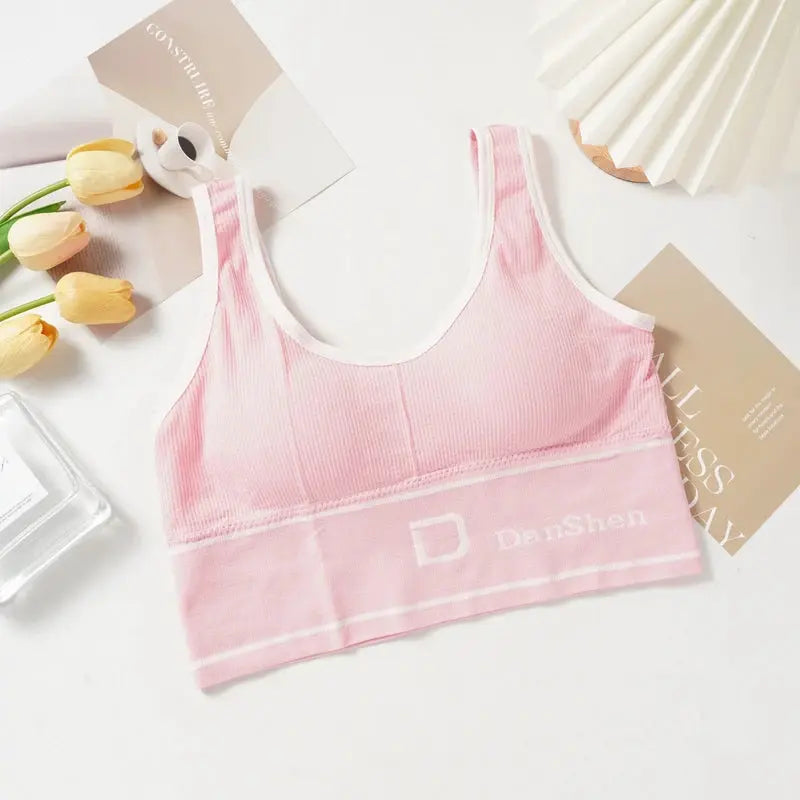 Pink seamless sports bra with white trim, wireless full-coverage; Danshen logo on band