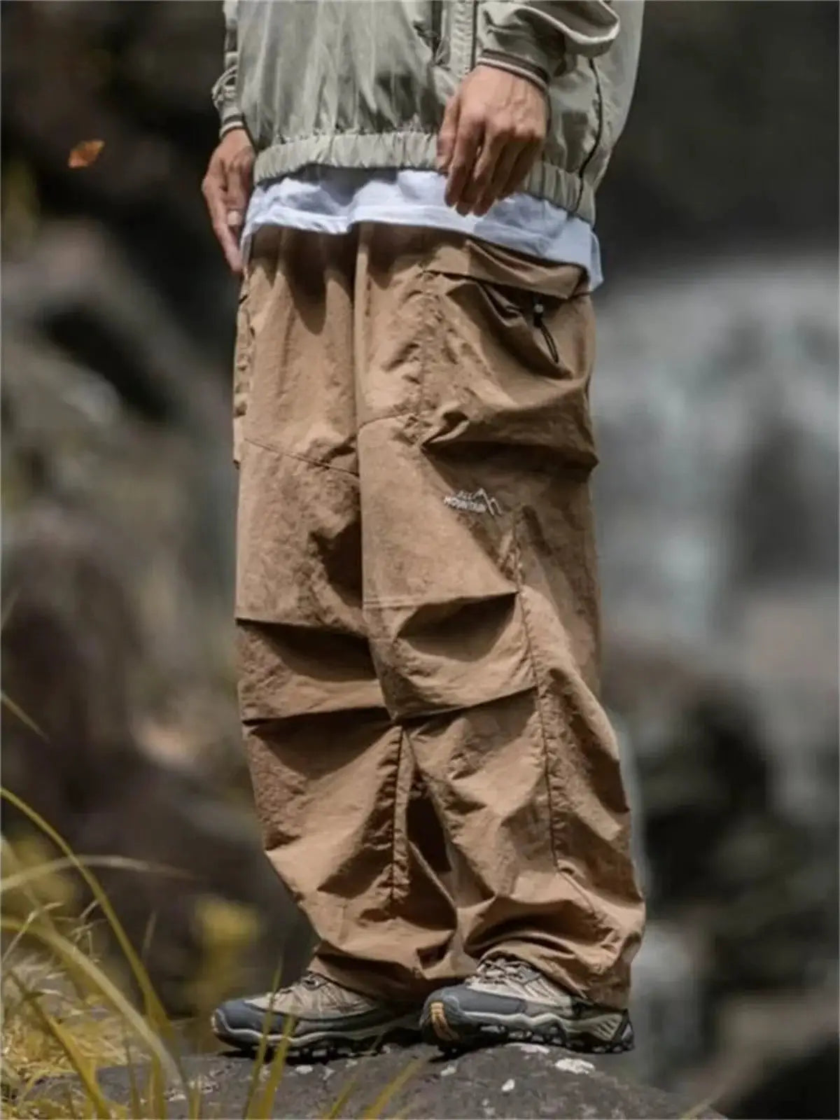 Men's tan cargo hiking pants by Simples Market with multiple utility pockets for outdoor mountaineering.