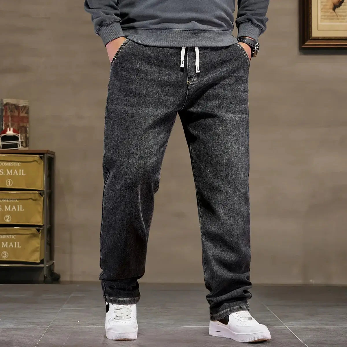Men's plus-size black denim jeans with high-elastic waist and drawstring, baggy fit.