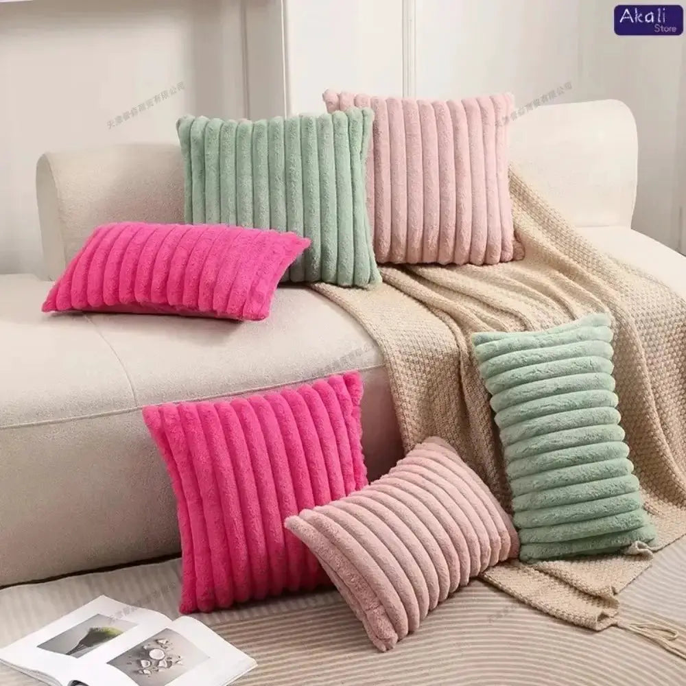 Faux rabbit fur cushion covers in pink, mint green and beige plush ribbed cushions on a sofa