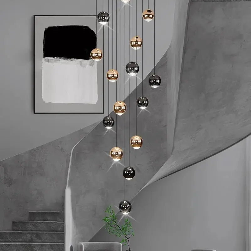 Pendant light fixture with cascading gold and black LED spheres for a modern living room chandelier.