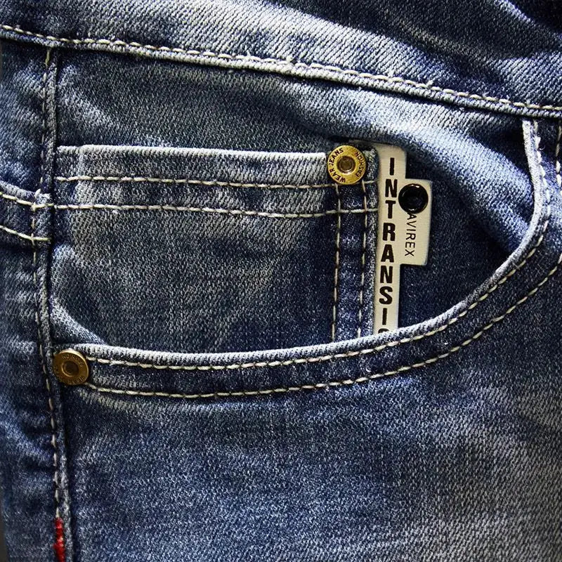 Men's blue denim jeans with front pocket rivet and small metal tag