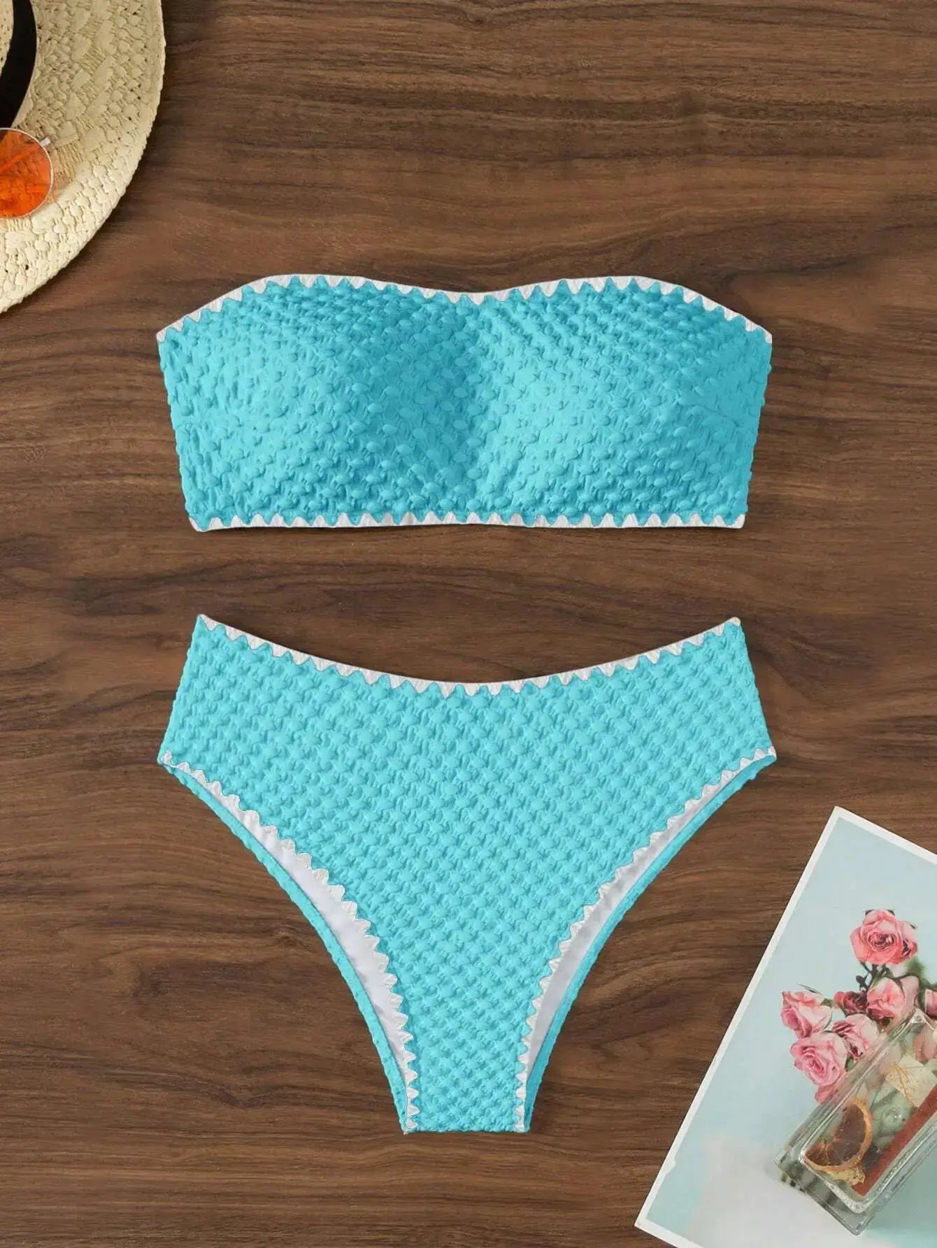 Turquoise strapless two-piece bikini with textured fabric and white scalloped trim, bandeau top and matching bottom.