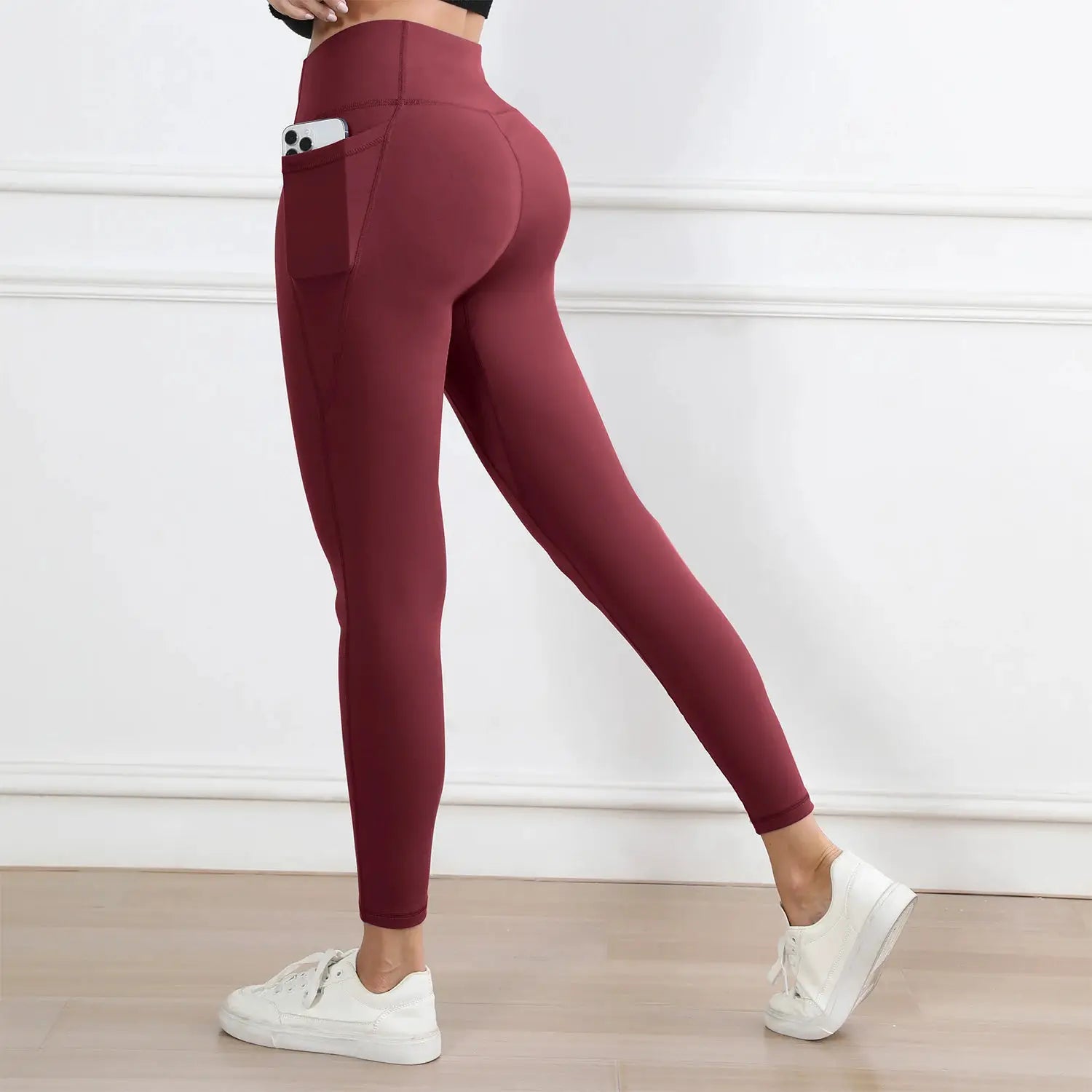 Women’s burgundy high-waist leggings with a side pocket; butt-lifting, stretchy workout tights.