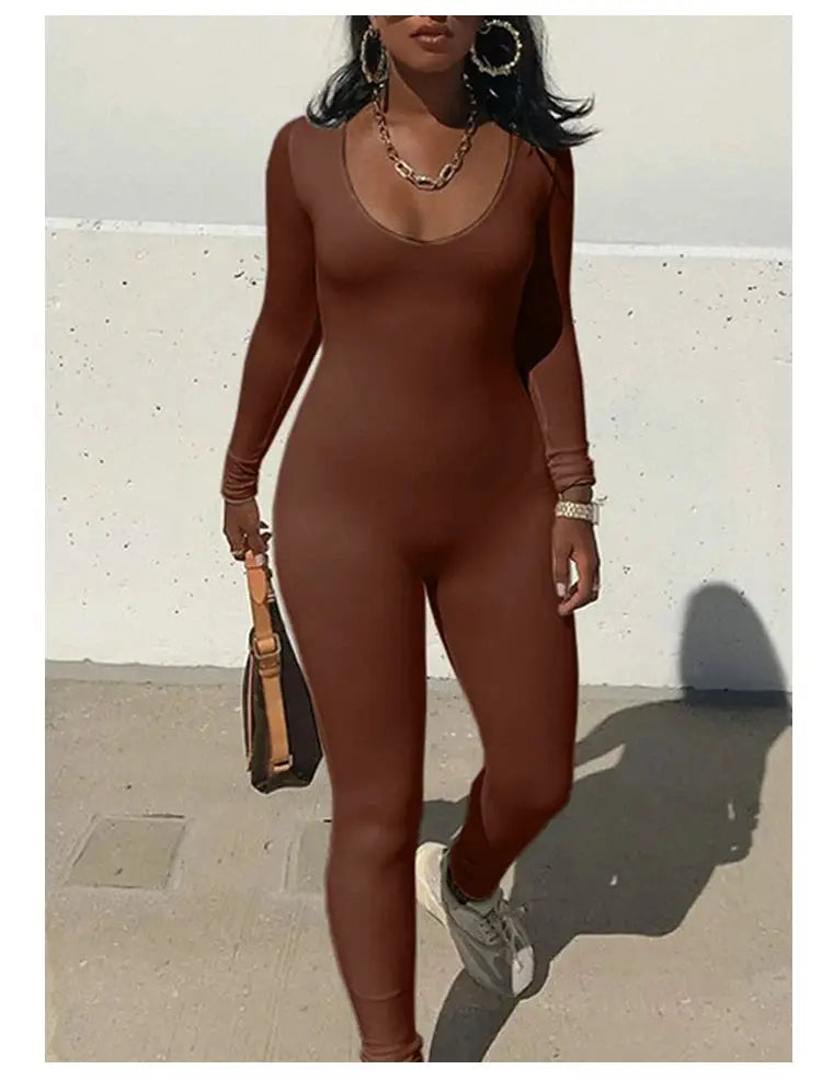 Women's brown solid-color long-sleeve jumpsuit, skinny fit, paired with sneakers and handbag.