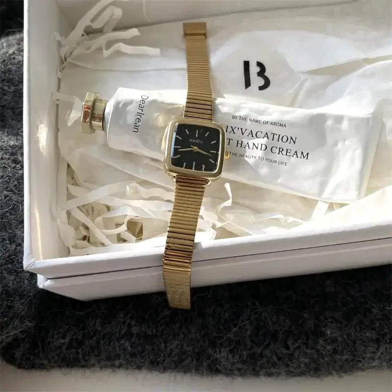 Gold-tone stainless steel women's quartz watch with square black dial and adjustable bracelet in a gift box