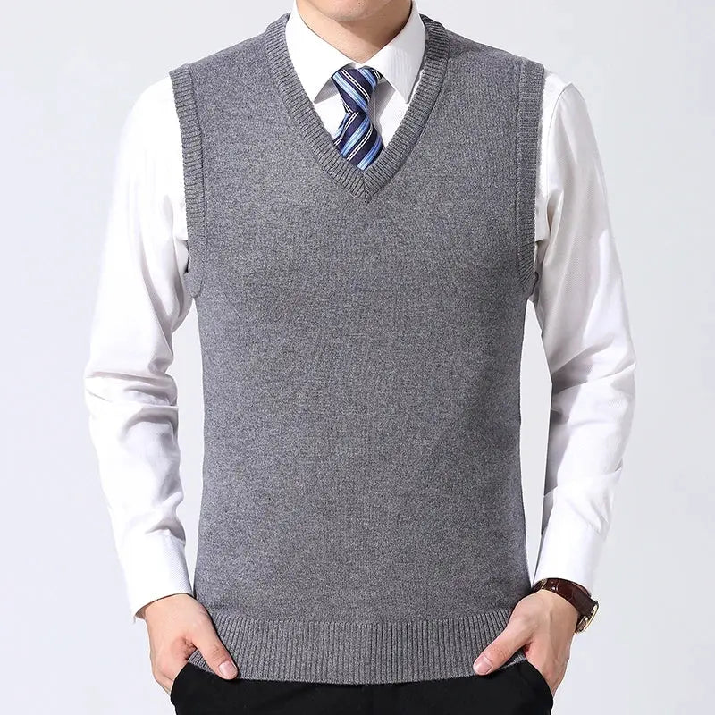 Men's grey knit sweater vest by Simples Market worn over white dress shirt with blue striped tie