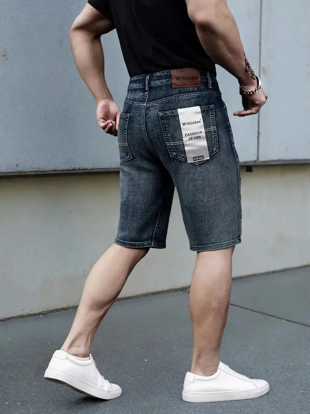 Men's blue denim shorts with back pocket tag and brown leather brand patch.