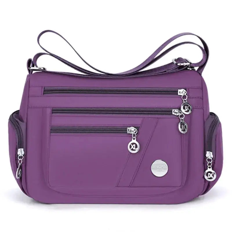 Purple nylon ladies' crossbody bag by Simples Market with multiple zip pockets and shoulder strap