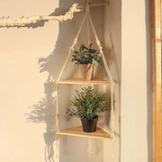 Two-tier wood triangle corner hanging shelf with rope hanger, displaying two potted plants.