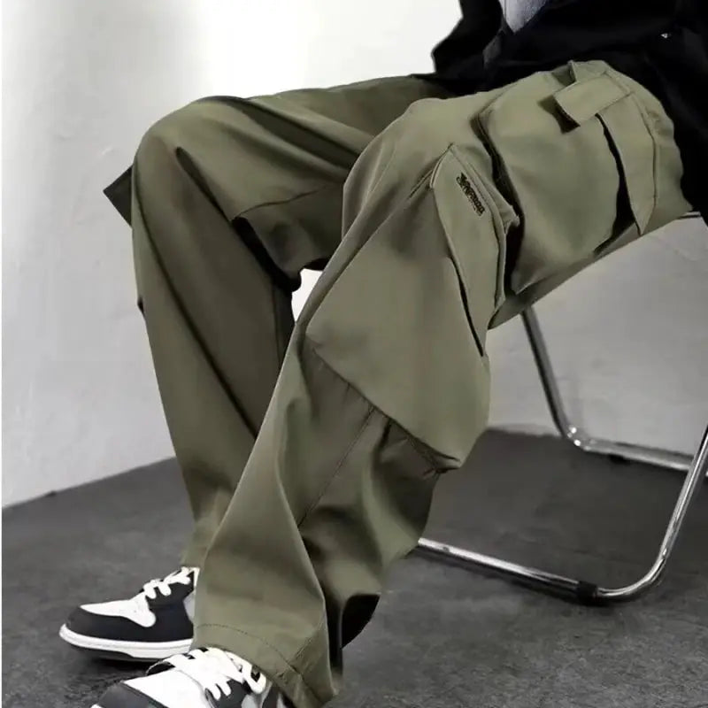 Men's olive green cargo jogger pants with multiple pockets, baggy fit.