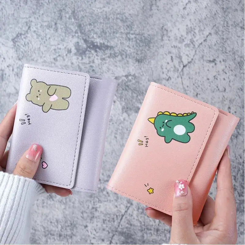 Two cute small wallets in lavender and pink with cartoon animal designs.