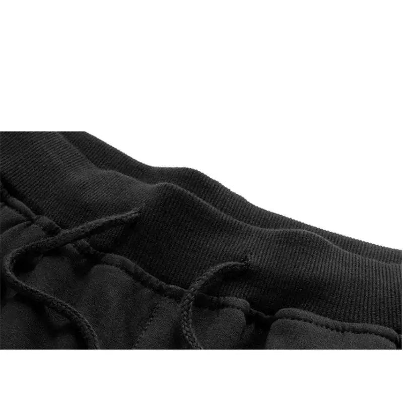 Men's black sport shorts waistband close-up with drawstring, knee-length gym shorts