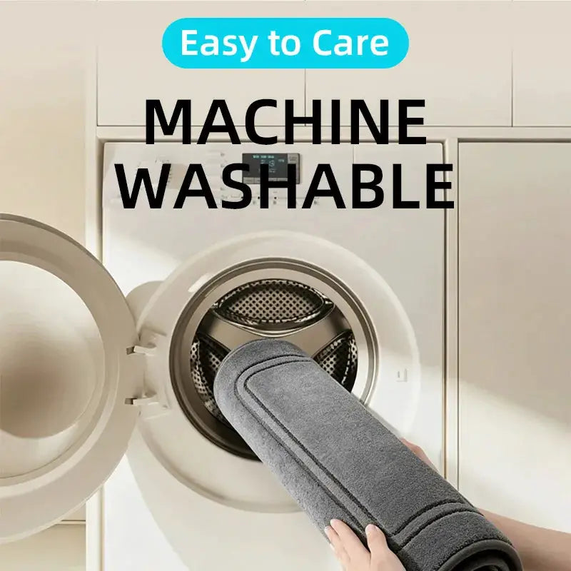 Grey bathroom rug being loaded into a front-loading washing machine; machine washable, quick-dry, non-slip