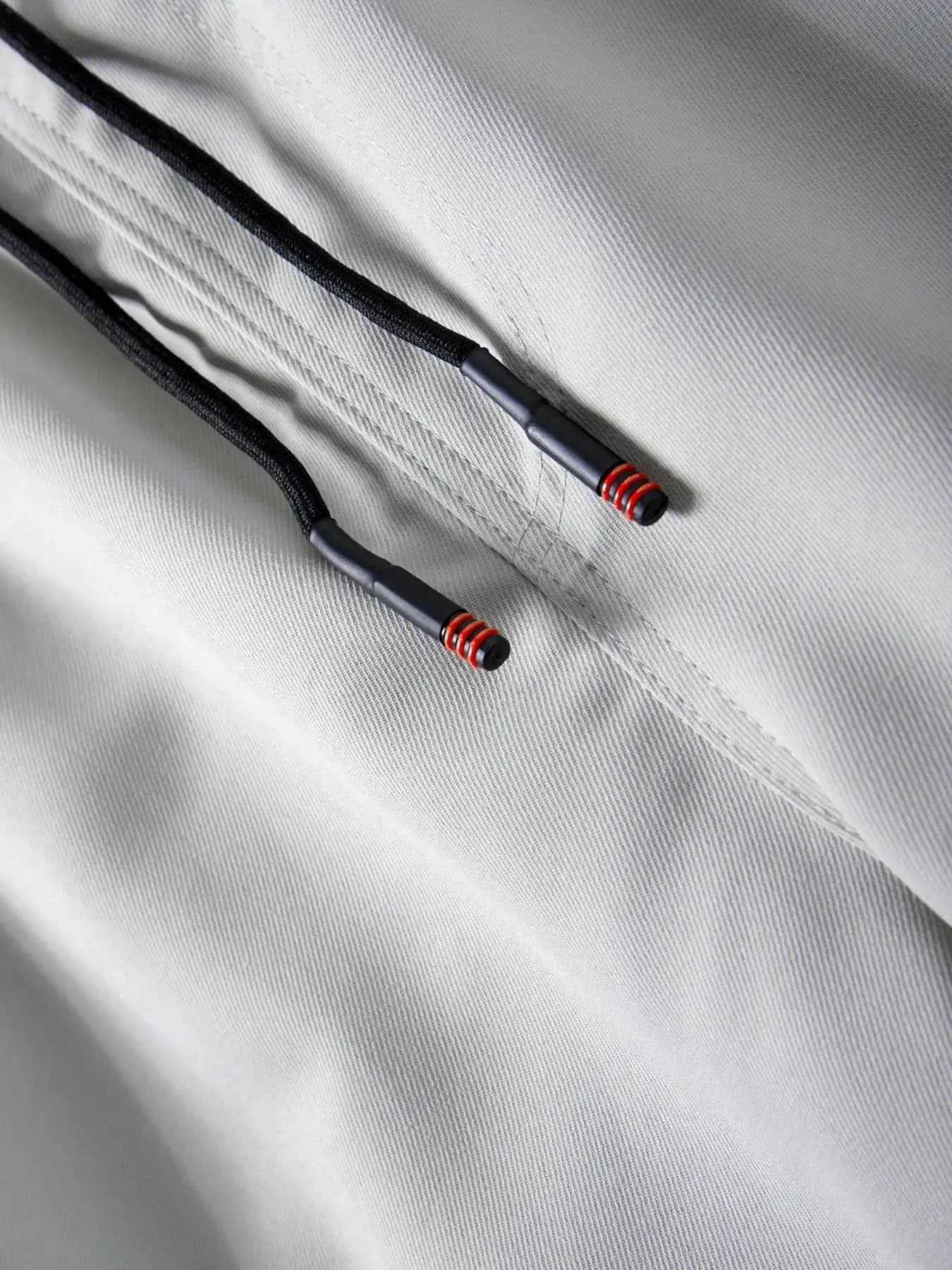 Men's cargo joggers by Simples Market with drawstring waist on gray fabric, black drawstrings with red-tipped ends.