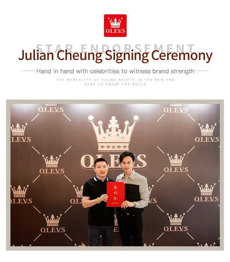 OLEVS signing ceremony photo with two men posing, one holding a red booklet, backdrop with OLEVS logos and crowns