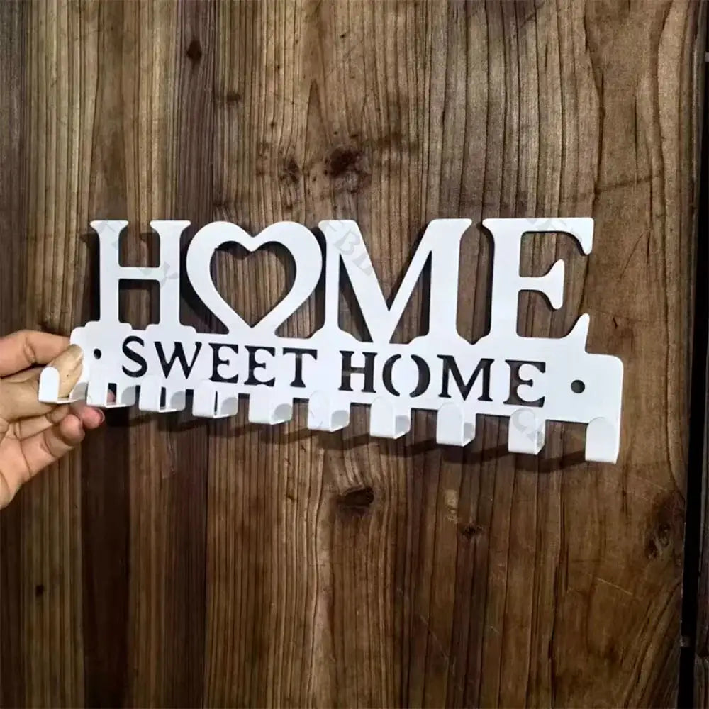 White metal wall-mounted key holder with HOME SWEET HOME design and multiple hooks