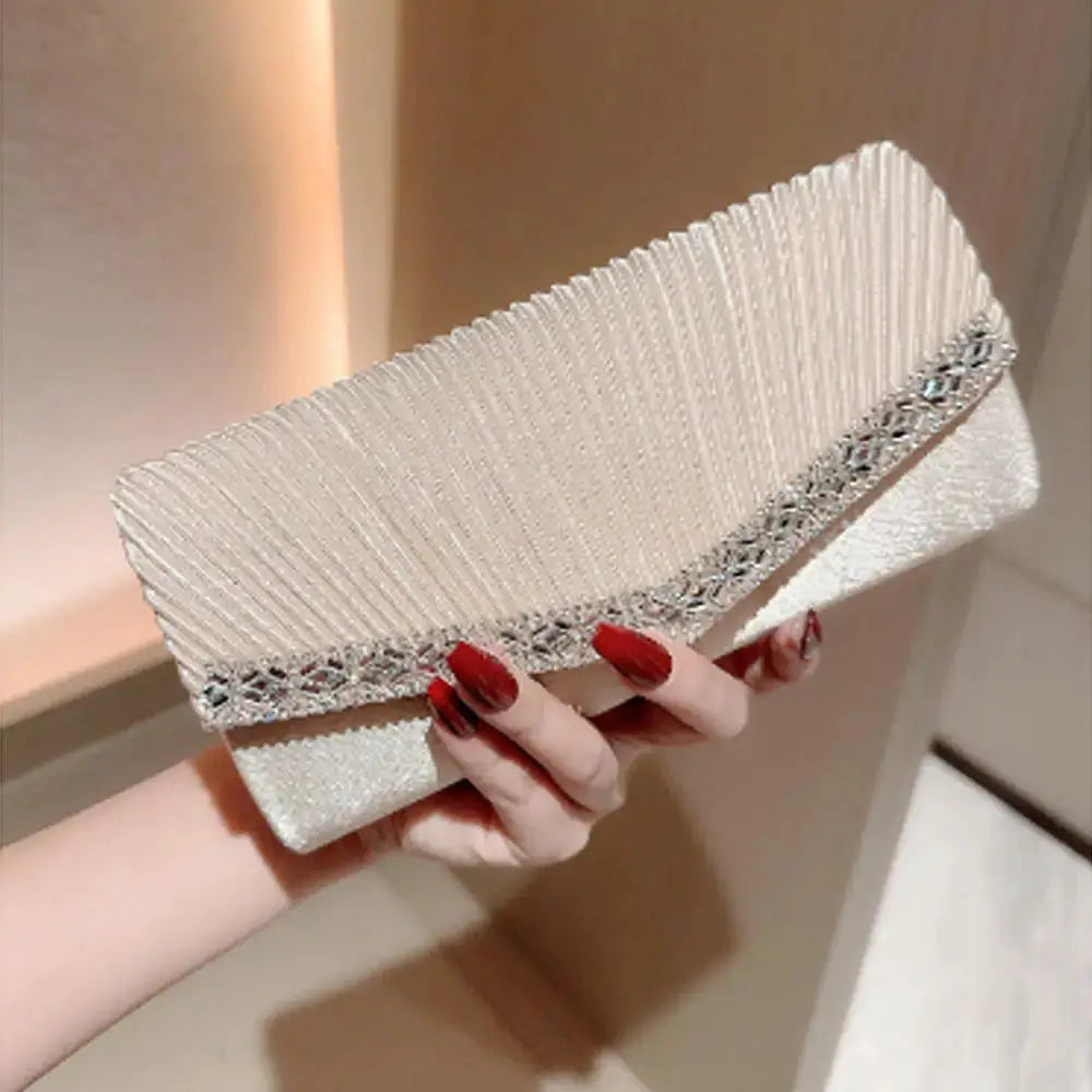 Women evening clutch bag in ivory with pleated texture and crystal-embellished silver trim.