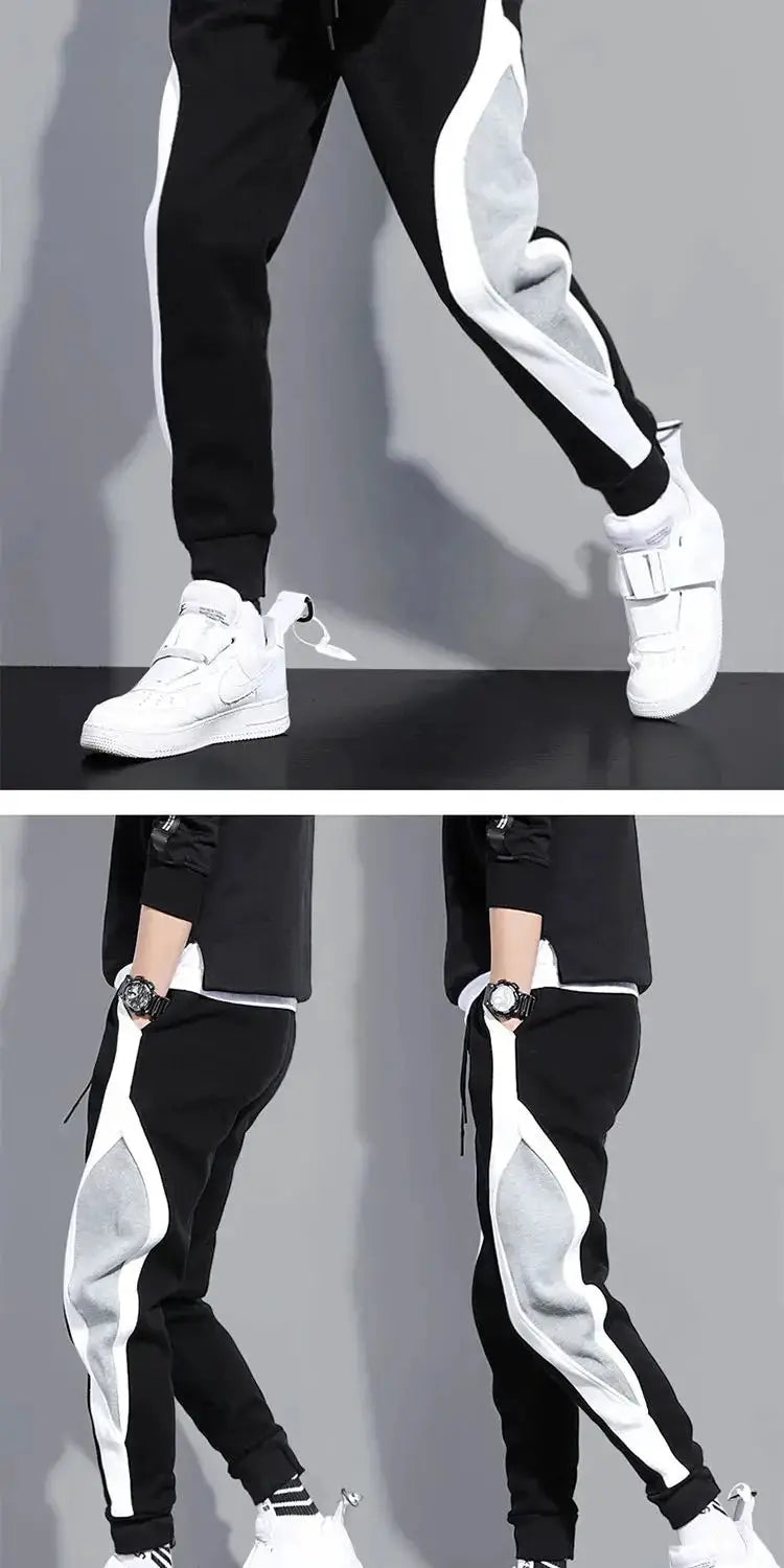 Men's wide loose patchwork jogger pants in black with white and gray side panels and elastic cuffs