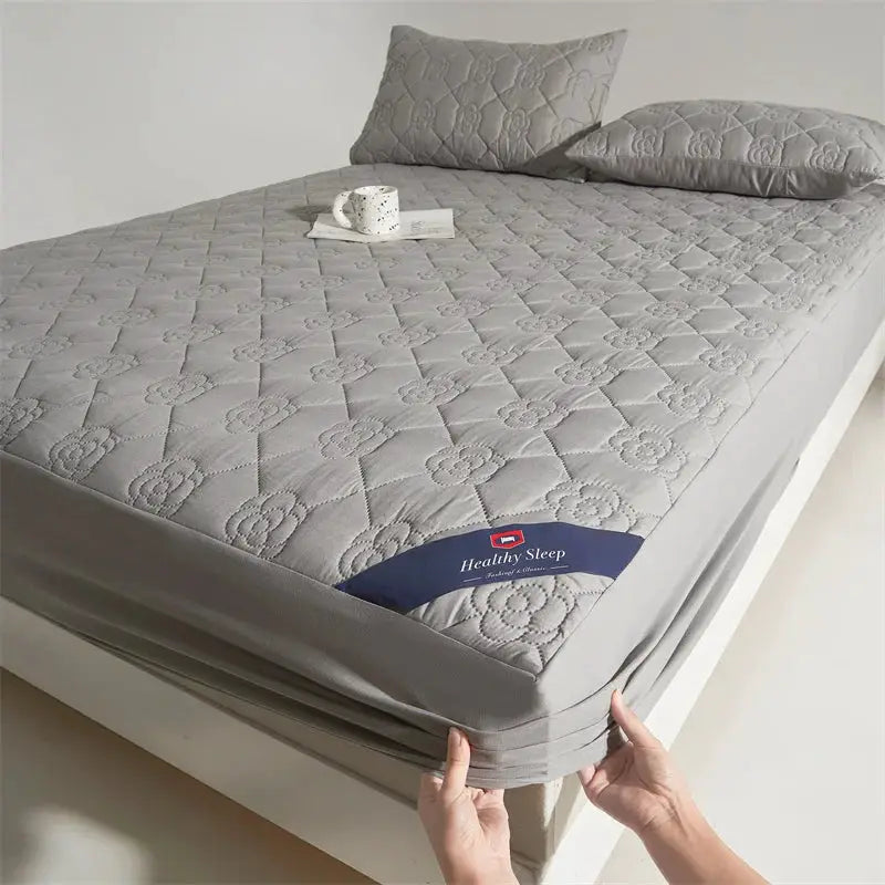 Waterproof grey quilted mattress protector with deep-pocket fitted sheet for single or double bed.
