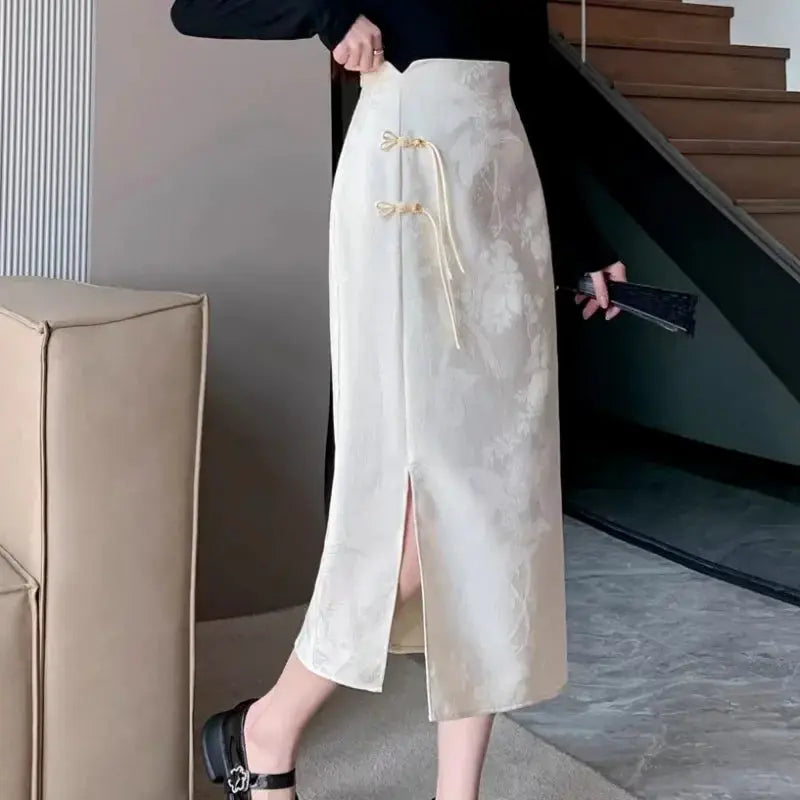 Chinese style high-waist midi skirt by Simples Market, ivory floral print with front bow-tie accents and side slit.