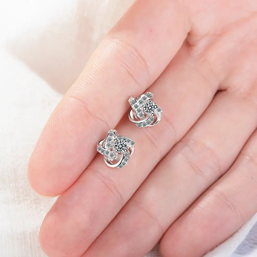 Pair of sterling silver earrings with zirconia stones and eternal heart twist design