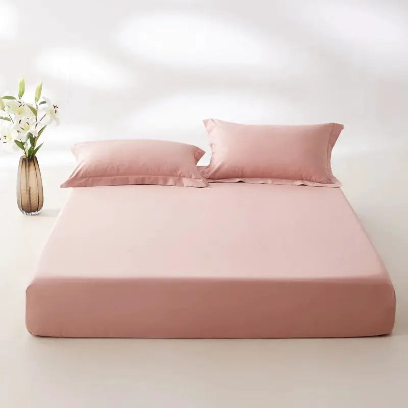 Egyptian cotton fitted sheet in pink on a neatly made bed with matching pink pillowcases