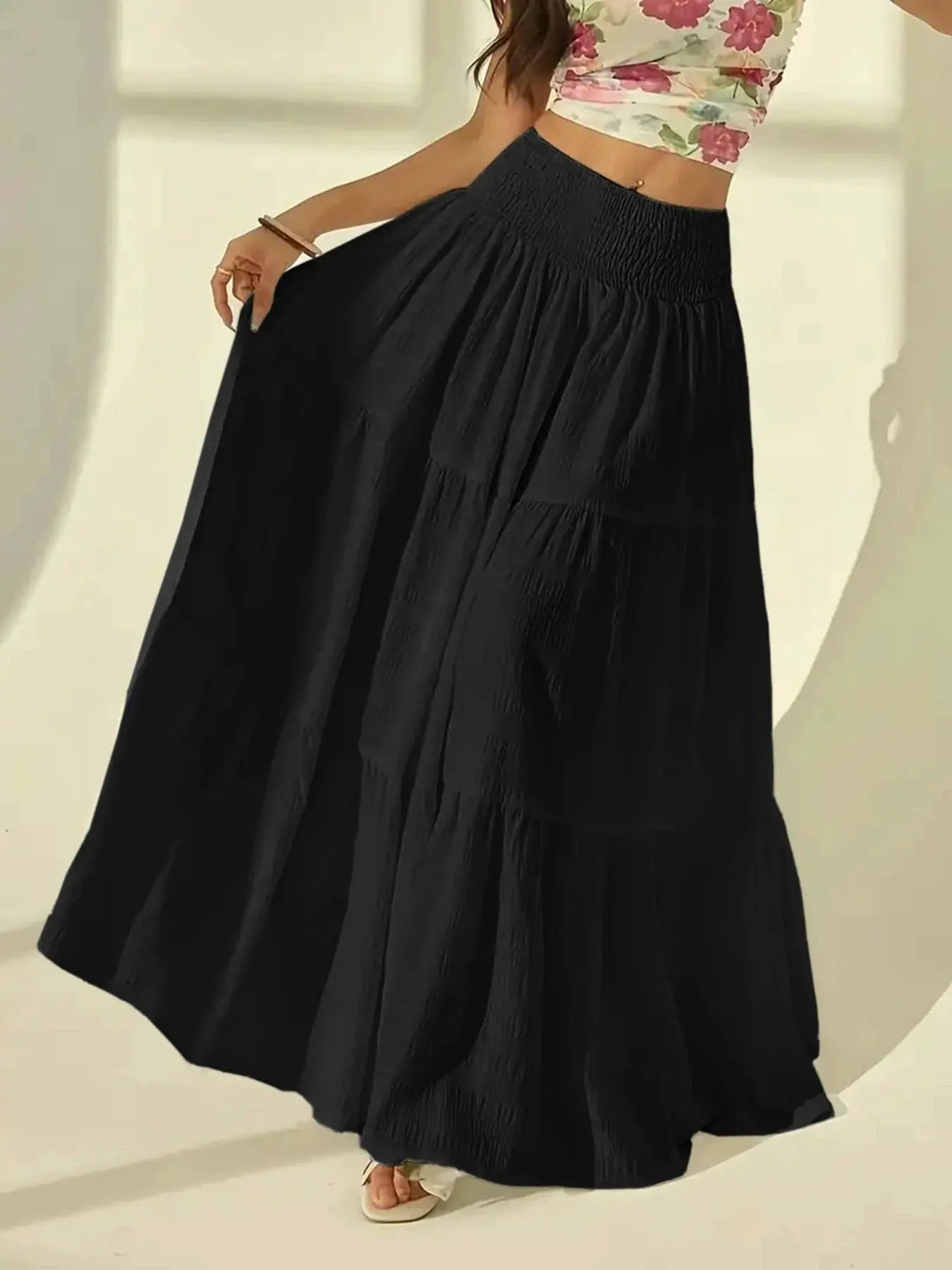 Simples Market black tiered maxi skirt with high-waisted elastic smocked waistband and flowing pleated design.