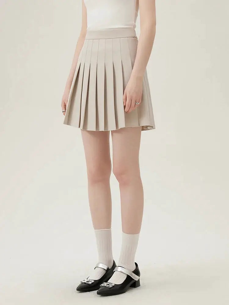 Beige pleated skirt set with white top for office wear.