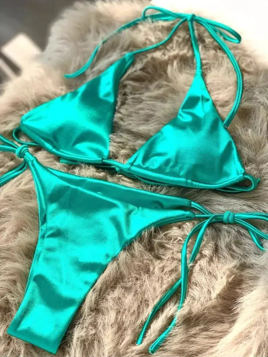 Bikini set in turquoise metallic satin, two-piece halter top with high-cut bottoms and tie strings.