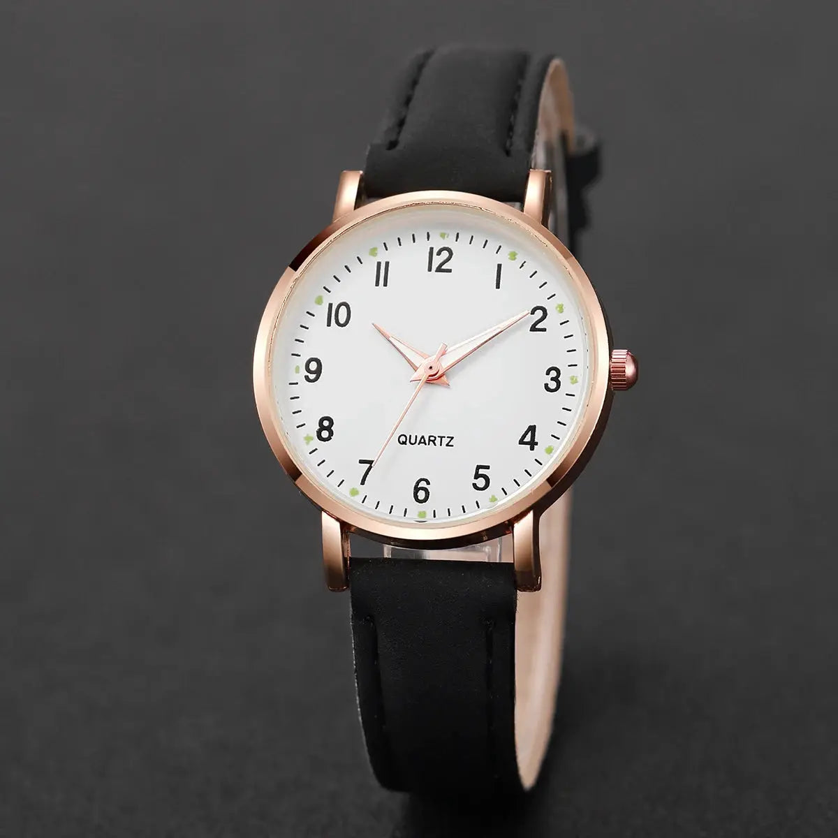 Women's quartz wristwatch with rose-gold case, white dial, and black leather strap