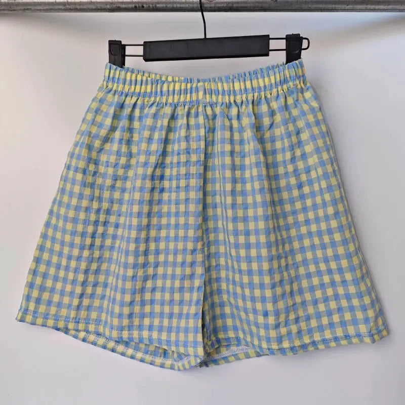 Summer Home Shorts: women's high-waisted blue and yellow plaid gingham shorts with elastic waistband.