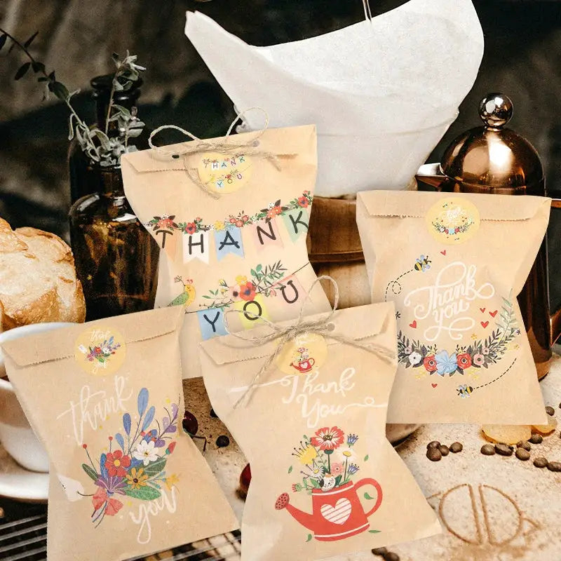 Five kraft paper thank-you gift bags with colorful florals and bunting accents.