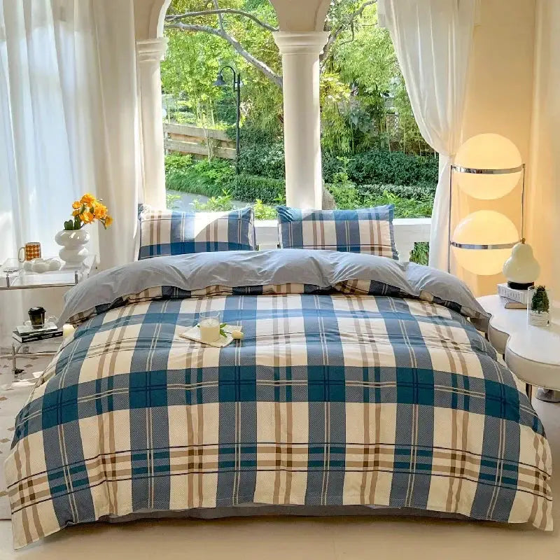 Blue plaid duvet cover set with 2 matching pillowcases arranged on a bed in a bright, airy room.