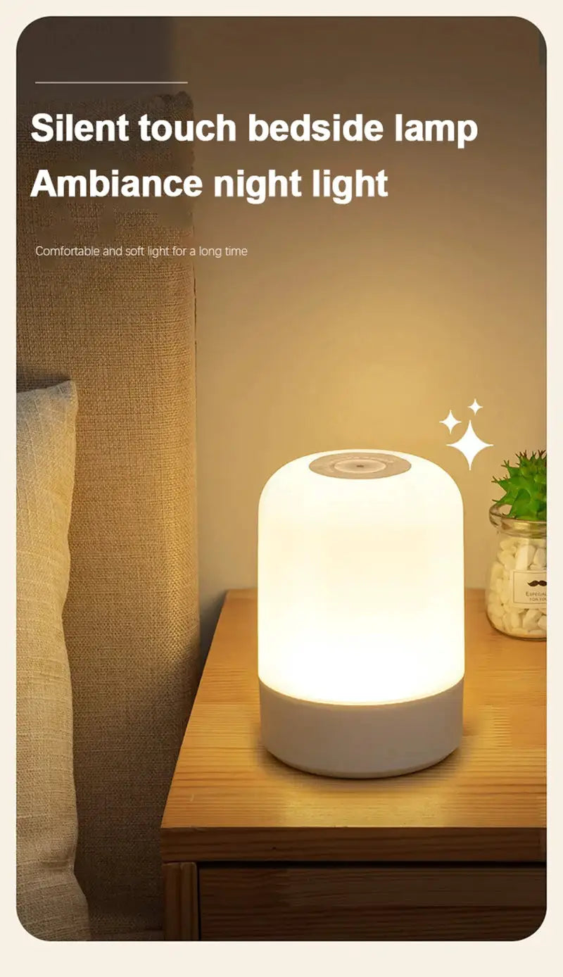 Simples Market LED bedside night lamp, white cylindrical touch-dim lamp with warm glow on a wooden nightstand.