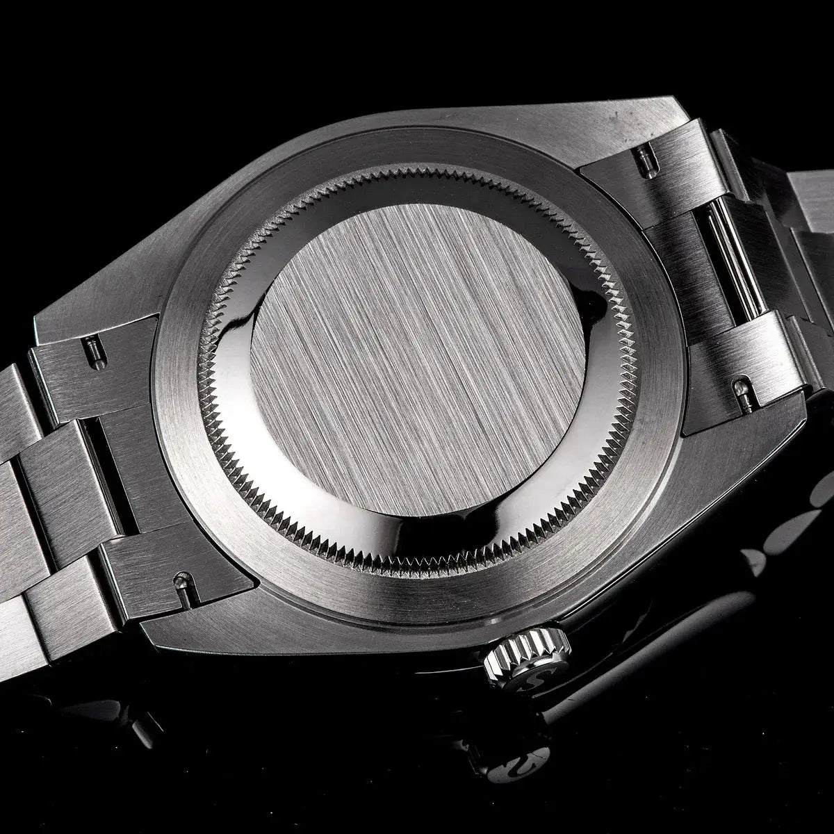 Men's stainless steel wristwatch back view with screw-down case back and linked bracelet.