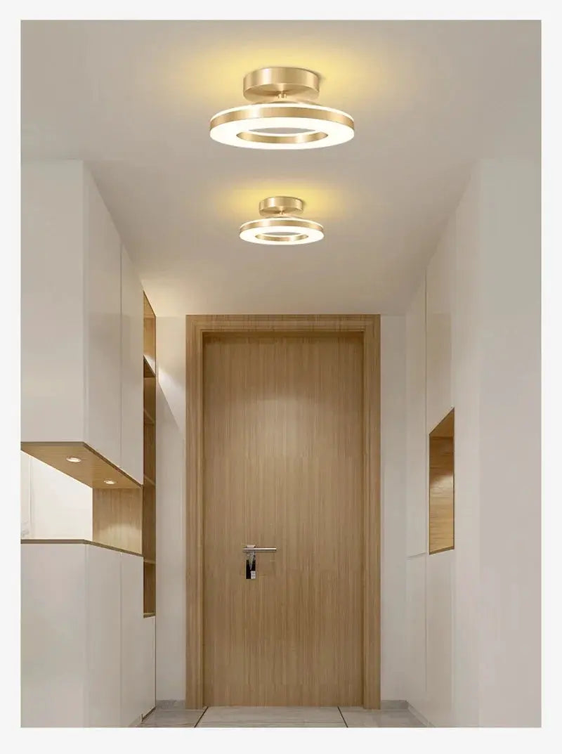 Two modern LED circular ring ceiling lamps in gold finish with warm white glow